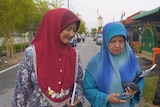 Suporters of Malaysian PM walk along a street