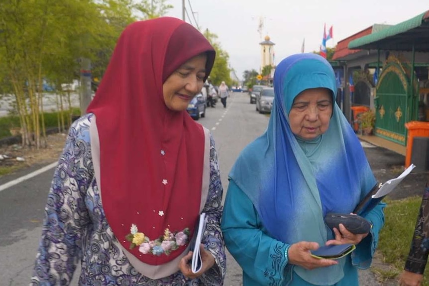 Suporters of Malaysian PM walk along a street