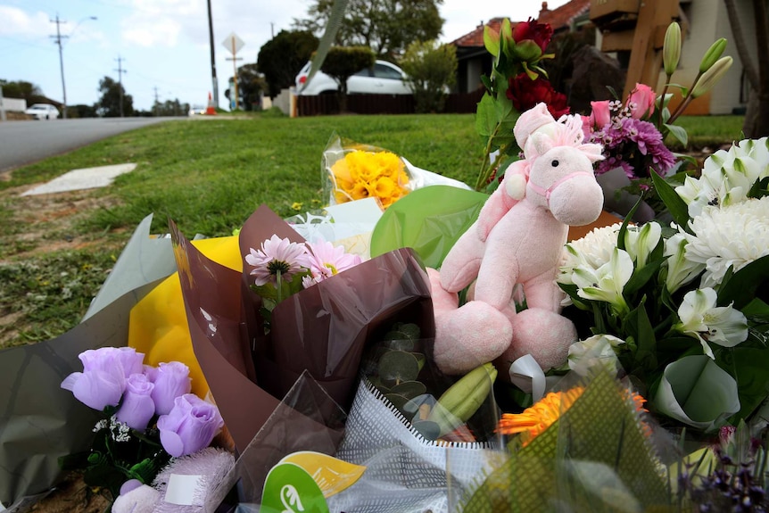 Flowers lie on the ground outside a house in Coode Street, Bedford, after two women and three children were found dead.