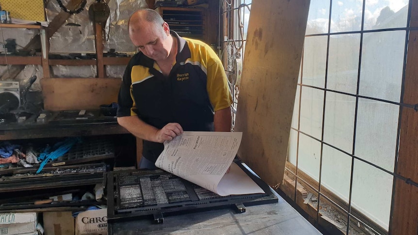 Michael English, the owner and operator of the Don Dorrigo Gazette prints a copy on the letter press.