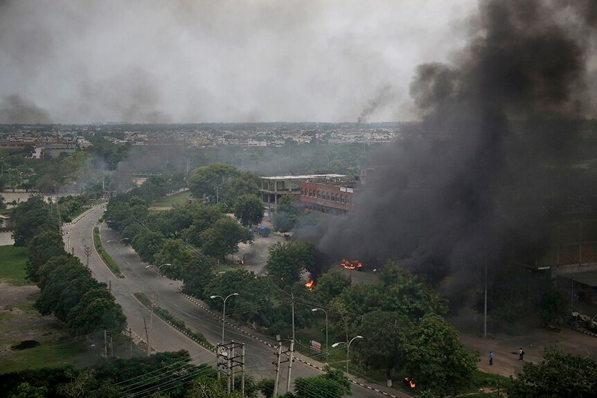 Smoke billows after supporters of the Dera Sacha Sauda sect set vehicles on fire near in Panchkula, India.
