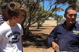 Man talks to farmer about how to set a wild dog trap.
