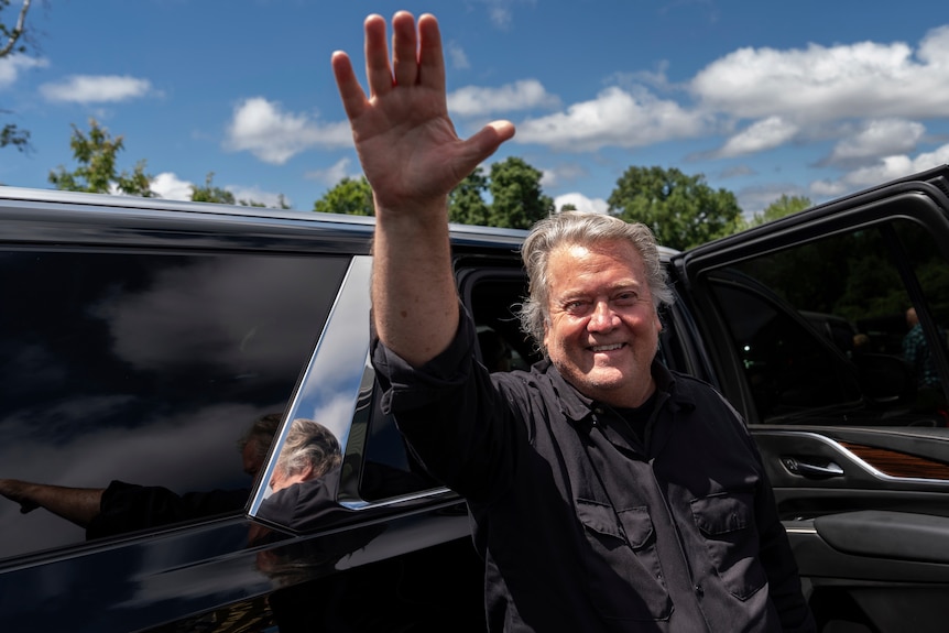 Man waves standing in front of open door at car 