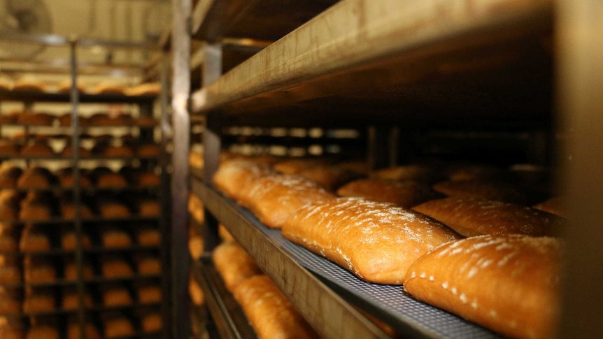 Fresh bread sitting on racks at a wholesale bakery