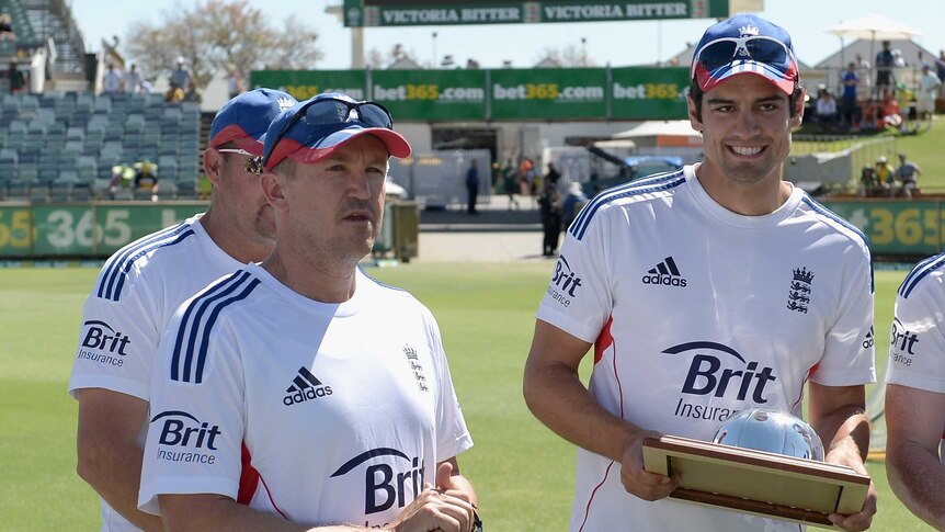 England captain Alastair Cook is presented with his 100th Test cap with coach Andy Flower in Perth.