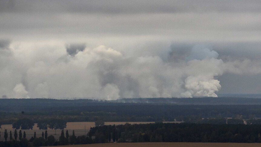 Smoke rises after explosions at a Ukrainian ammo depot.