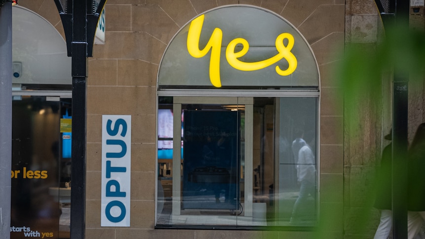 A sandstone window with yellow "yes" writing and an Optus sign.