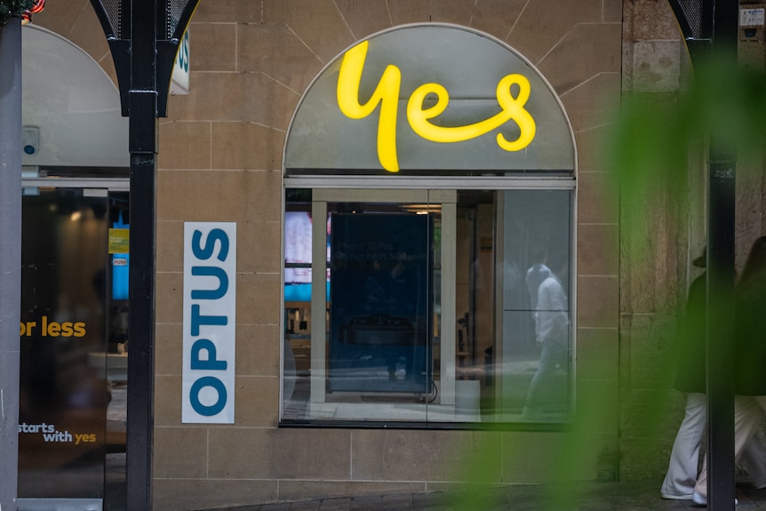 A sandstone window with yellow "yes" writing and an Optus sign.