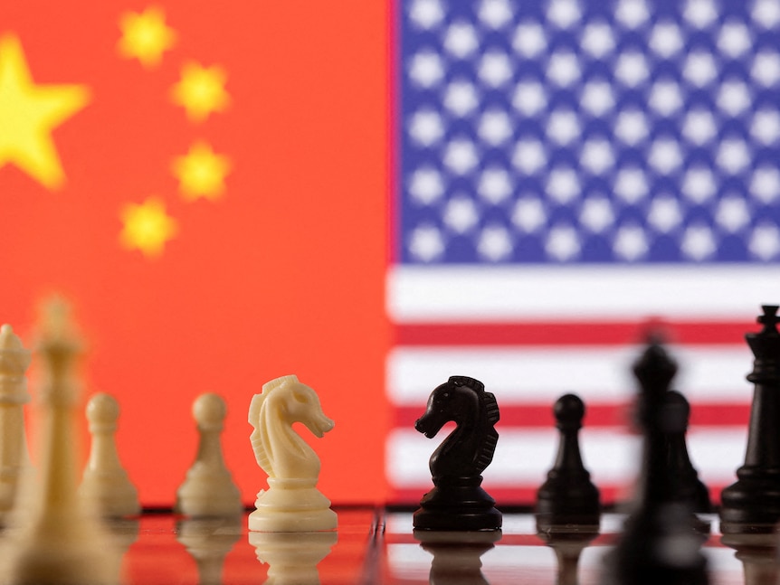 Chess pieces are seen in front of displayed China's and U.S. flags.