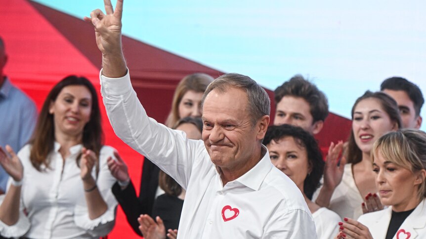 Opposition leader Donald Tusk grins and puts his hand up in a peace gesture after recent election win