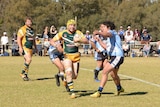 Men playing rugby league at a country sports ground