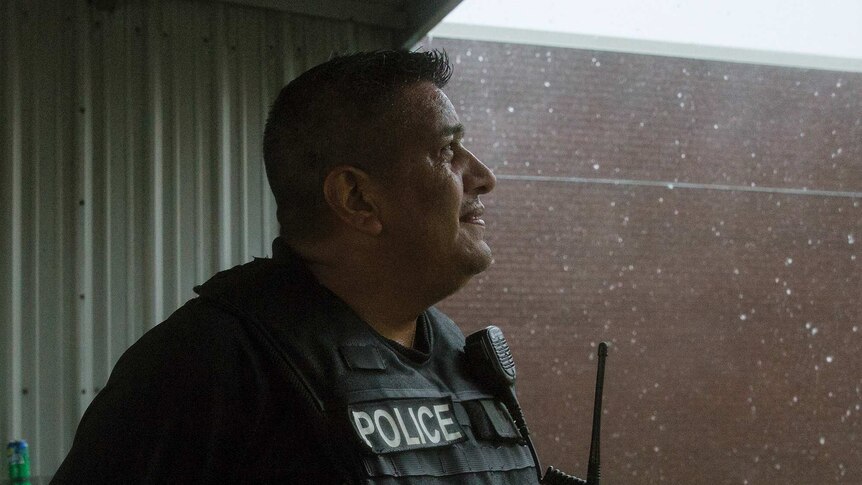 Javier Ramos of the Port Lavaca Police Department looks up at the rain.
