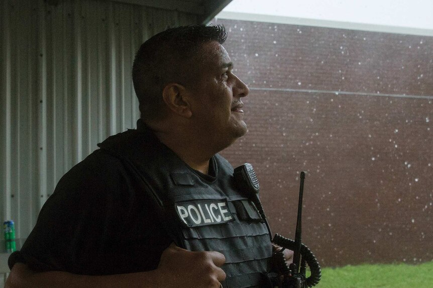 Javier Ramos of the Port Lavaca Police Department looks up at the rain.