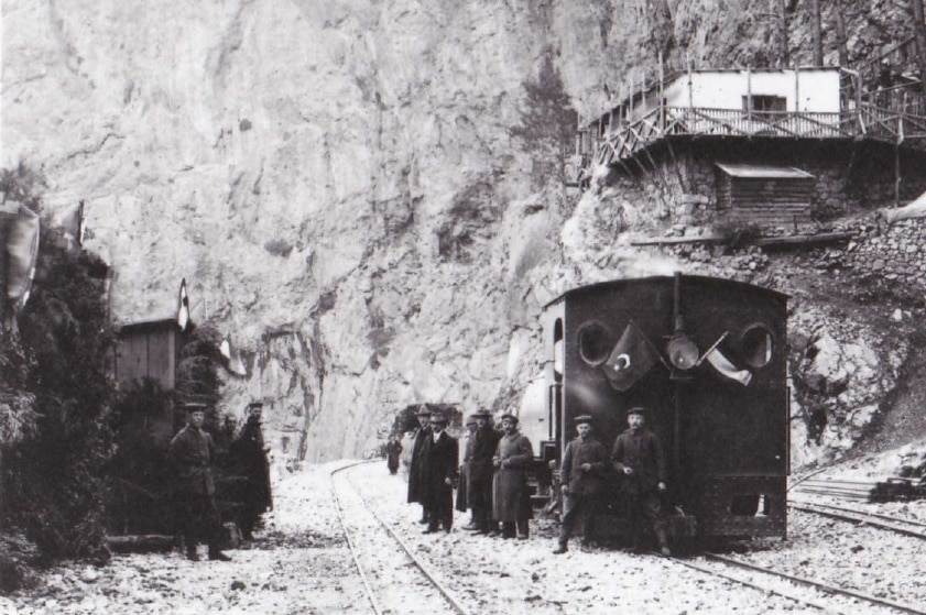 Photo of an old-fashioned railway carriage and rail cutting through a gorge