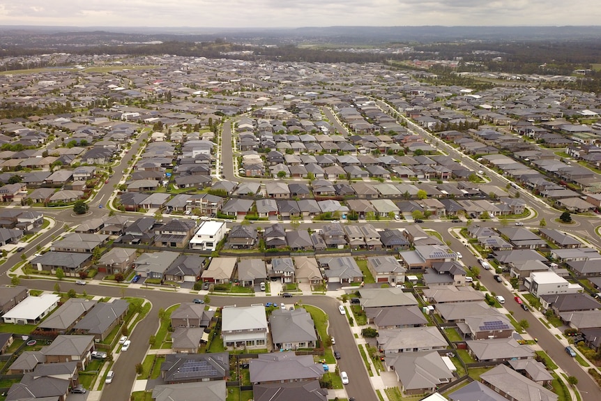 Una vista aérea de cientos de casas repartidas en tierras verdes.