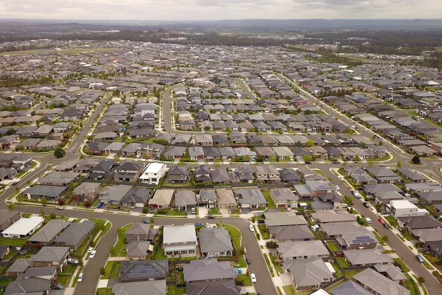 An aerial view of hundreds of houses spread across green lands