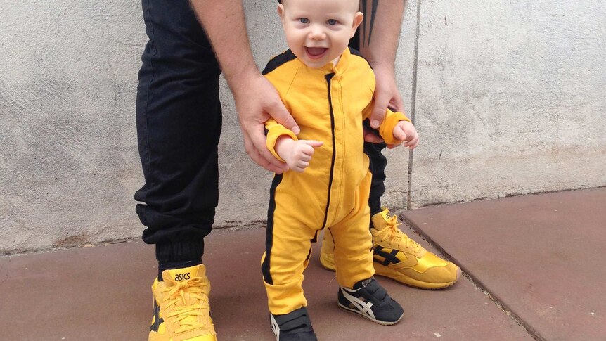 Lee Ingram and his son as a baby wearing matching sneakers and outfits