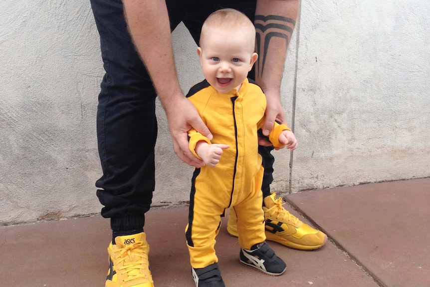 Lee Ingram and his son as a baby wearing matching sneakers and outfits