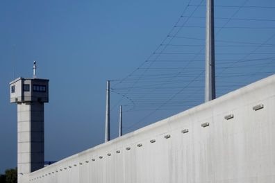 A large wall and watchtower of the prison