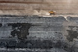 Photo of a truck driving along a mining shelf in a coal pit