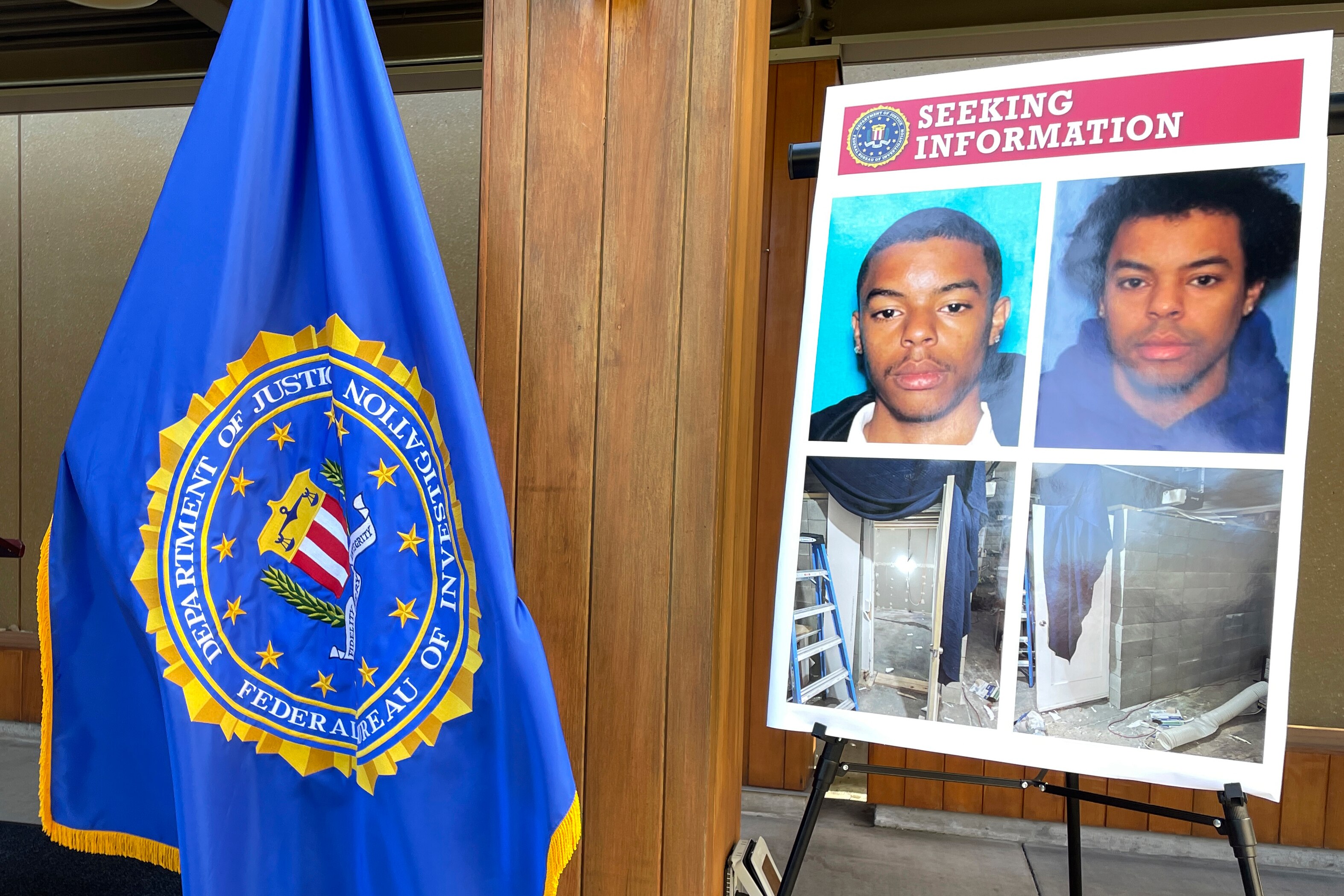 An FBI flag and a seeking information posterboard  the boared has two pictures of the offender and the cell