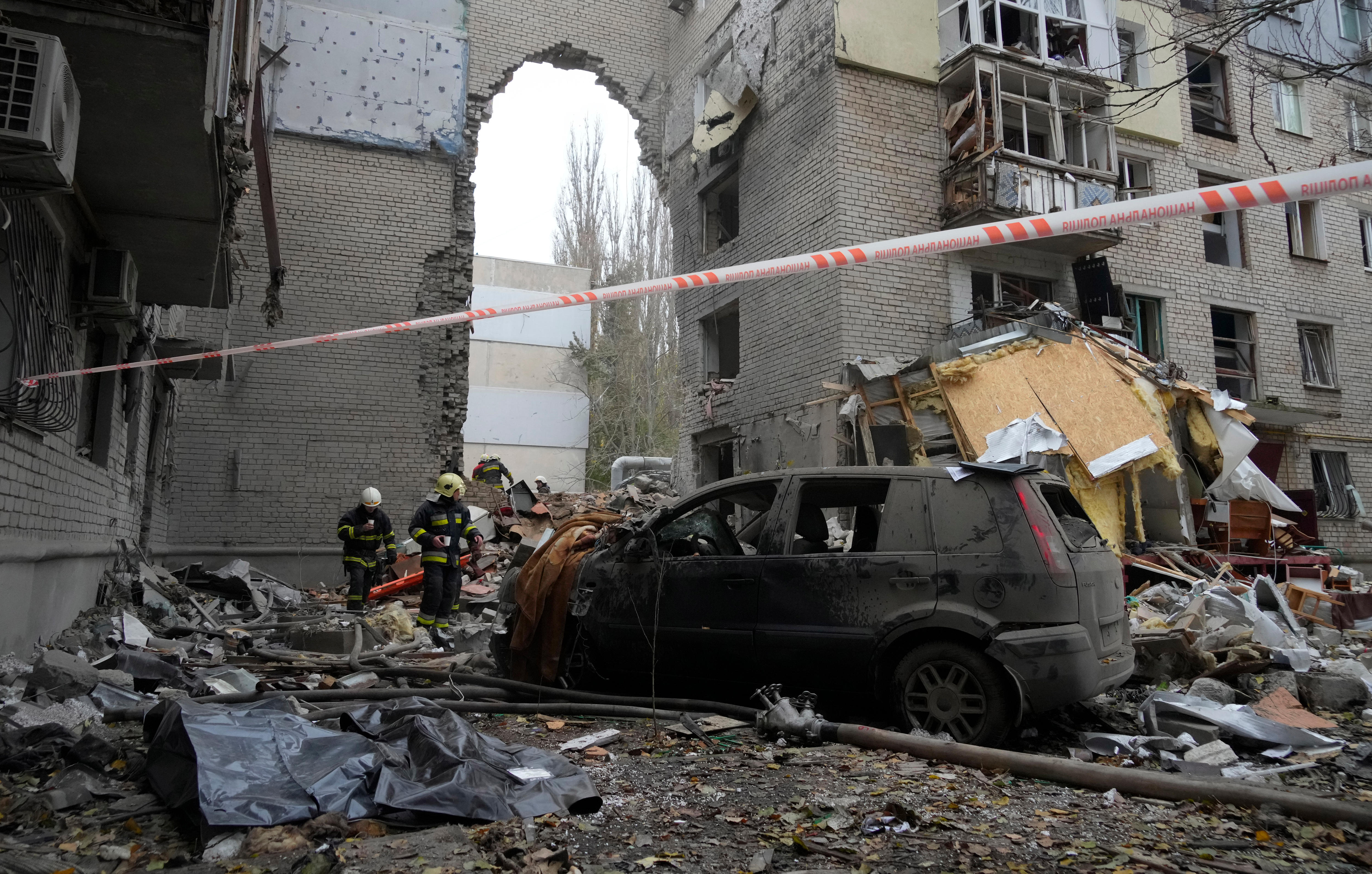 Emergency workers at the site of a shelled building.