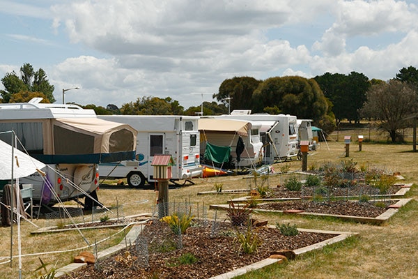 A caravan park with several vans lined up.