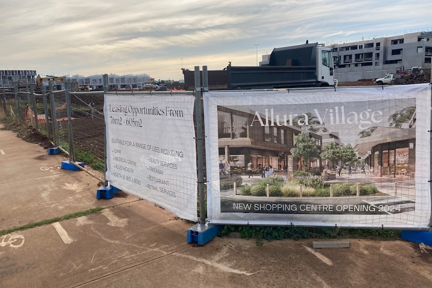 A sign saying Allura Village and new shopping centre opening soon.