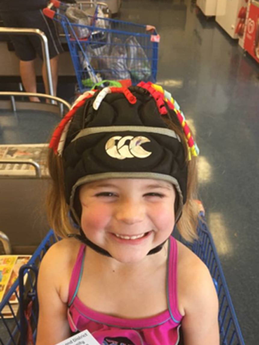 daughter smiling with rugby helmet on.