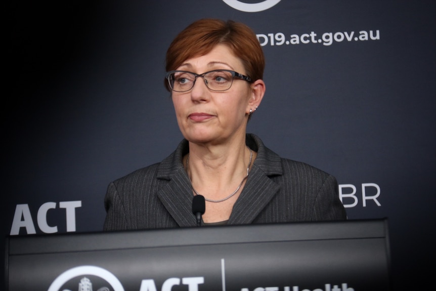 ACT Министр здравоохранения Рэйчел Стивен Смит стоит перед, казалось бы, встревоженной трибуной.