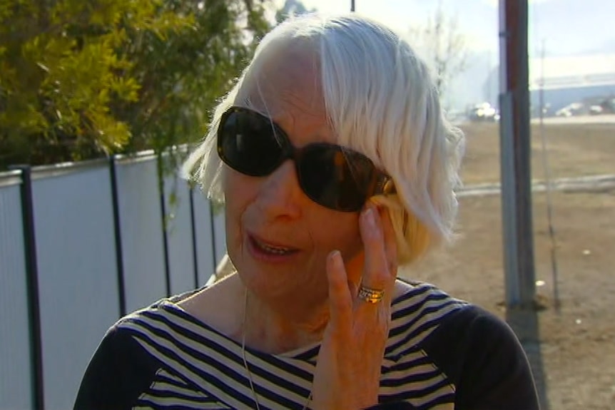 A woman with sunglasses cries.