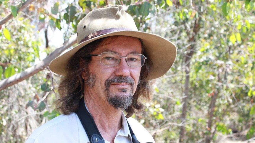 Mike Bamford standing in the wetlands, wearing a hat and glasses.