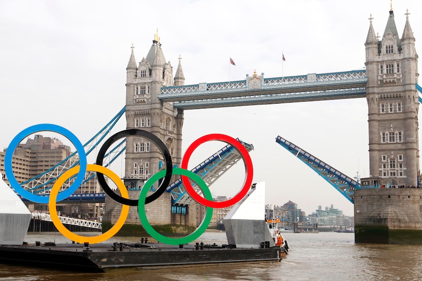 A barge with the Olympic rings mounted on it approaches Tower Bridge in London. (Reuters: Andrew Winning)