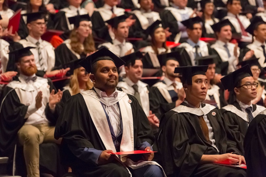 Dinesh Palipana sitting in his wheelchair at his graduation ceremony