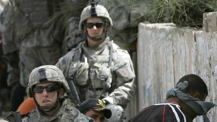 US soldiers stand guard near blindfolded suspected insurgents in Iraq