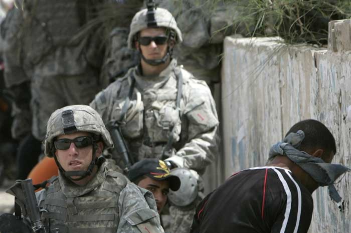 US soldiers stand guard near blindfolded suspected insurgents in Iraq