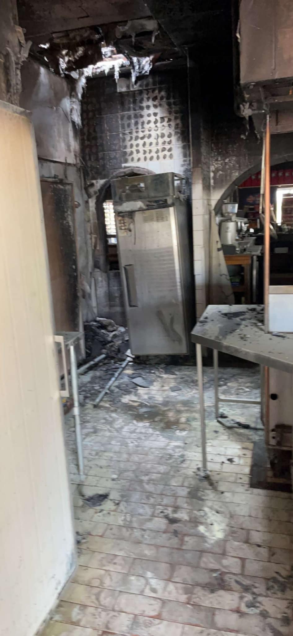 Blackened remains of a fridge in a kitchen.