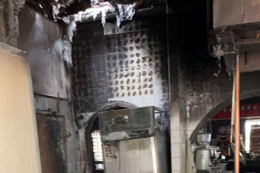 Blackened remains of a fridge in a kitchen.