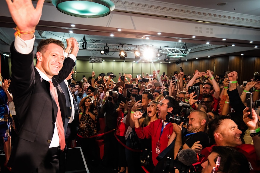 Man holding up his hands in front of a crowd