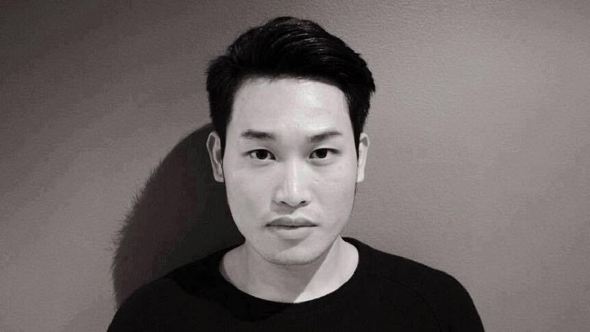 Portrait of Garry Nguyen standing against the wall