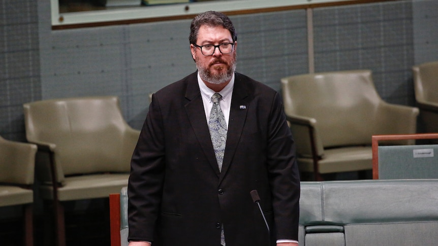 George Christensen stands at his desk in the house of representatives