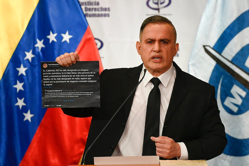 Venezuela Attorney-General Tarek William Saab holding up twitter posts during a press conference.