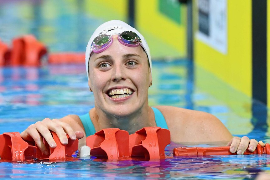 Alicia Coutts smiles as she holds on to lane rope in the pool after a swim