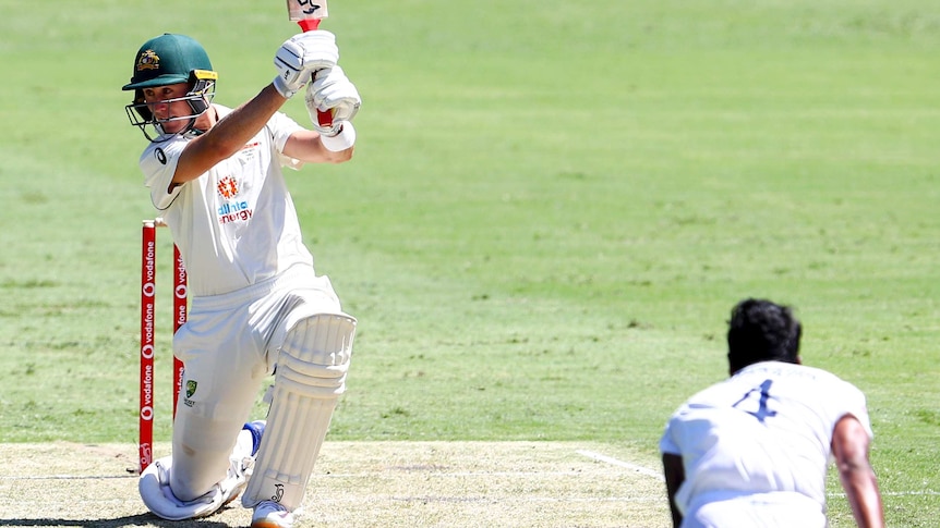 Australia batsman Marnus Labuschagne goes down on one knee as he completes a shot against India bowler T Natarajan.