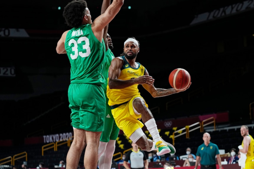 Australia's Patty Mills drives around Nigeria's Jordan Nwora at the Tokyo Olympics.