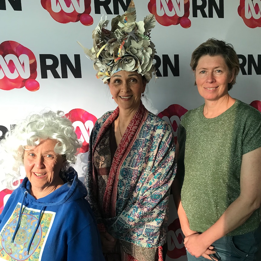 three women in front of RN sign. Two wearing costume wigs