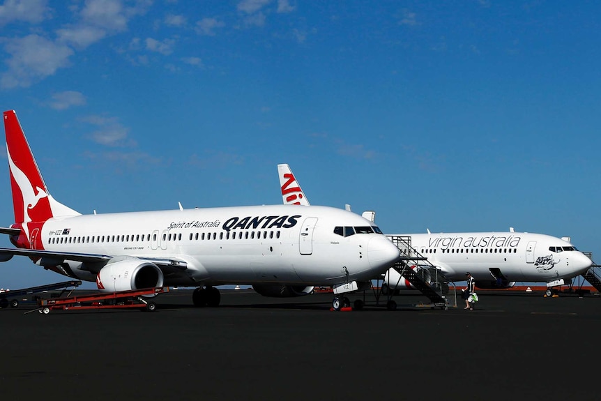 Qantas planes beside Virgin plane