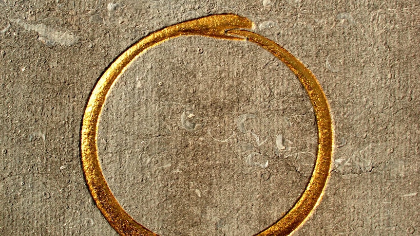 A patterned relief of a gold worm eating its own tail