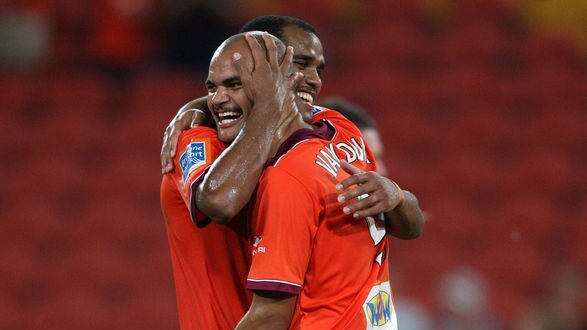 Partners in crime... Sergio Van Dijk and Reinaldo embrace after Brisbane's third goal.