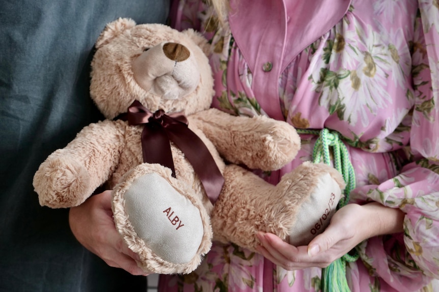 a large plush bear with Alby written on its foot